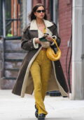 Irina Shayk a l'air à la mode dans un long manteau marron avec une tenue jaune lors de vos déplacements à Manhattan, New York City