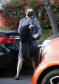 Mandy Moore couvre sa bosse de bébé avec un manteau alors qu'elle sort vêtue d'une robe à motifs à Los Angeles