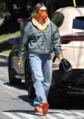 Hailey Bieber porte une veste verte avec un accent orange assorti à son masque et à ses baskets lors d'une visite à un ami à Los Angeles