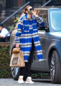 Gigi Hadid a l'air frappante dans un manteau à carreaux bleu alors qu'elle attrape de la nourriture à emporter dans Shake Shack à New York